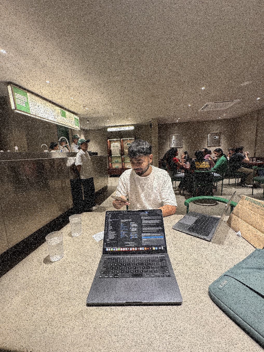 Sahil working on a laptop at a late-night cafe counter